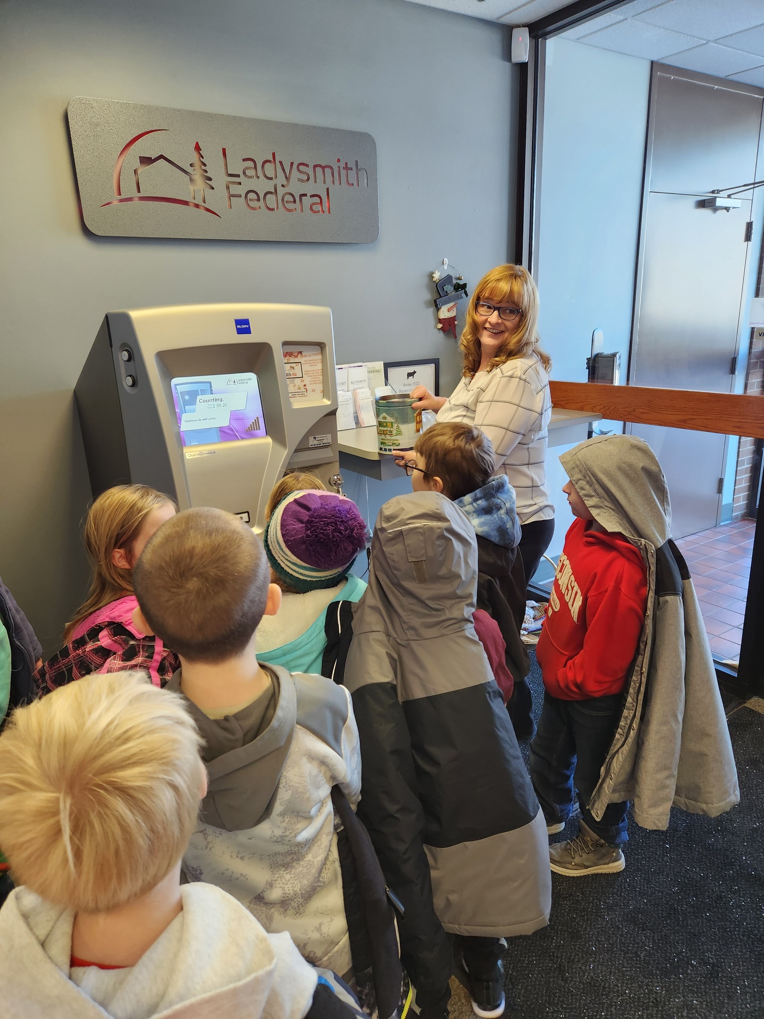 Bank Employee showing students how to use our coin machine
